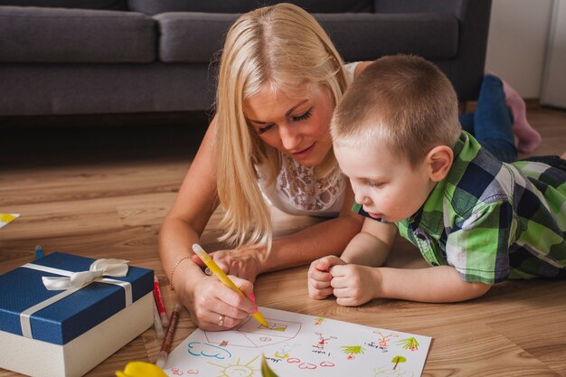 Nahaufnahme der jungen Mutter Zeichnung neben ihrem Sohn