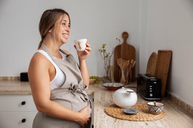 Nahaufnahme der jungen schwangeren Frau beim Kochen