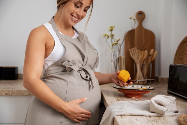 Nahaufnahme der jungen schwangeren Frau beim Kochen