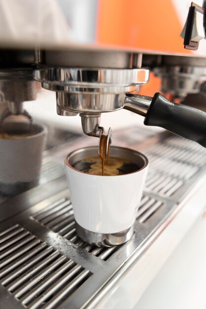 Nahaufnahme der Kaffeemaschine, die Kaffee in die Tasse gießt