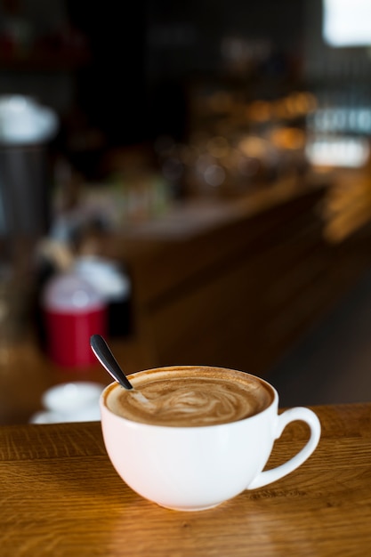 Nahaufnahme der lattekaffeetasse über tabelle Kostenlose Fotos
