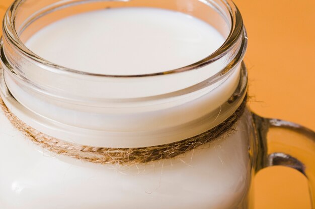 Nahaufnahme der Milch im Glasgefäß gebunden mit Schnur