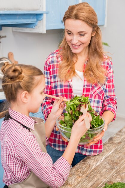 Nahaufnahme der Mutter und der Tochter, die den Salat zubereiten