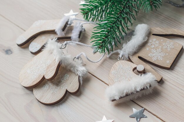 Nahaufnahme der niedlichen Weihnachtsdekorationen auf einem Holztisch unter den Lichtern