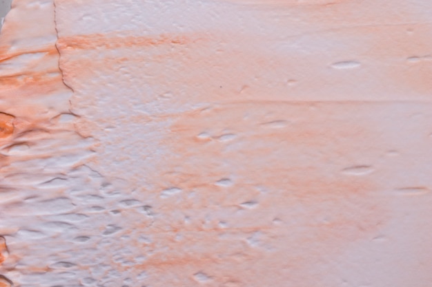 Kostenloses Foto nahaufnahme der orange farbenbeschaffenheit mischte mit weißer farbe auf zementwand