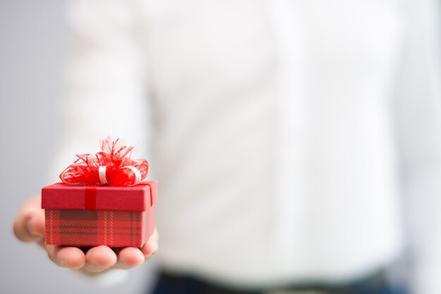 Nahaufnahme der Person kleine rote Geschenkbox mit Bogen gebend