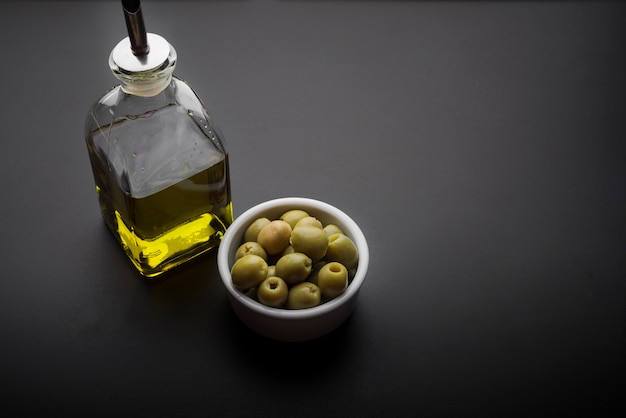 Nahaufnahme der Schüssel Oliven und des Olivenöls auf Küche worktop