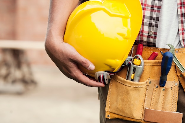 Nahaufnahme der Schutzhelmhaltung durch Bauarbeiter