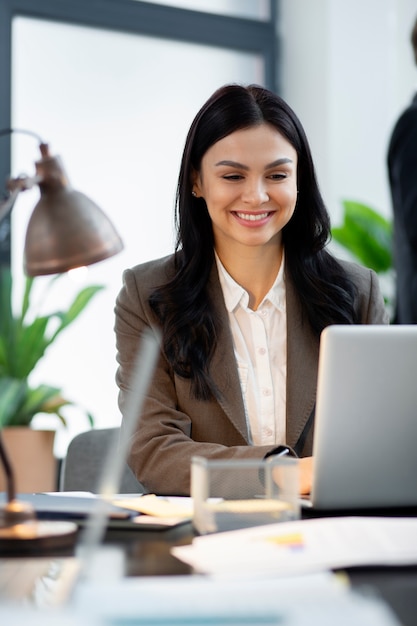 Nahaufnahme der Smiley-Frau, die am Laptop arbeitet