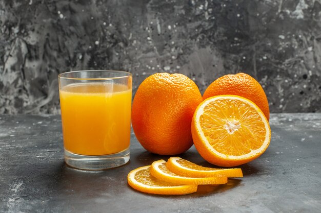 Nahaufnahme der Vitaminquelle geschnitten gehackte und ganze frische Orangen auf grauem Hintergrund