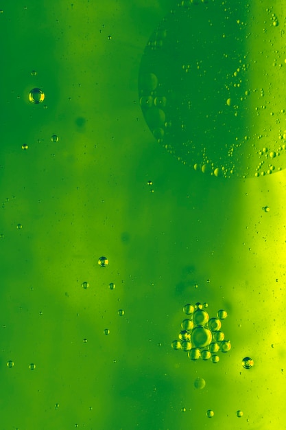 Nahaufnahme der Wasserblasen, die auf grünen Hintergrund schwimmen