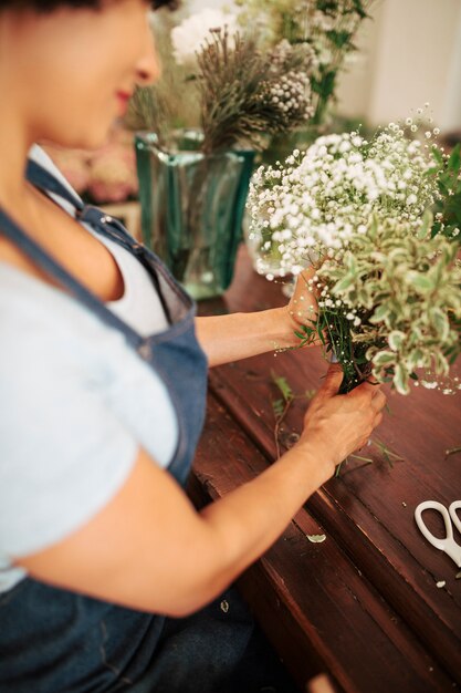 Nahaufnahme der weißen Blumenanlagen eines weiblichen Floristen Hand