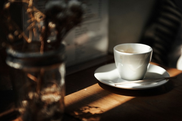 Nahaufnahme der weißen Kaffeetasse auf Holztisch