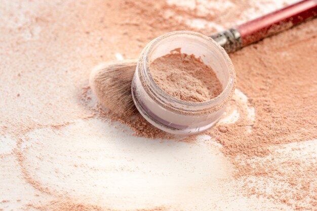 Nahaufnahme der zerquetschten mineralischen Schimmerpulvergoldfarbe mit Make-up-Pinsel