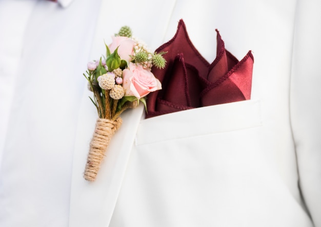 Nahaufnahme des Bräutigams Boutonnière auf Klagenrevers