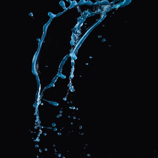 Nahaufnahme des Fallens des blauen Wassers auf dunklem Hintergrund