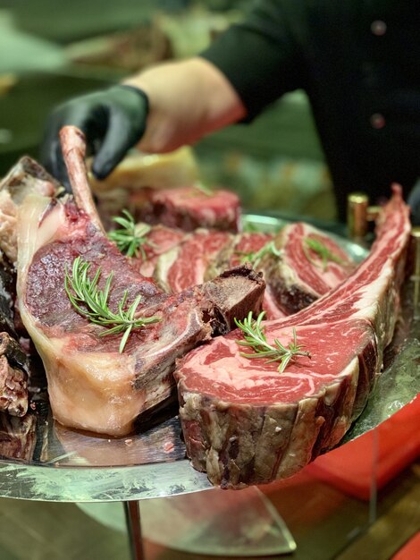 Nahaufnahme des gekochten roten Fleisches auf einer Metallplatte mit dem Koch im Hintergrund