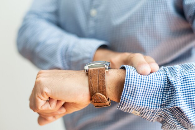 Nahaufnahme des Geschäftsmannes Zeit auf Uhr überprüfend