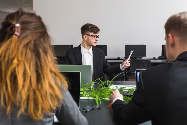 Nahaufnahme des Geschäftspartners sitzend vor dem Manager, der Dokument betrachtet