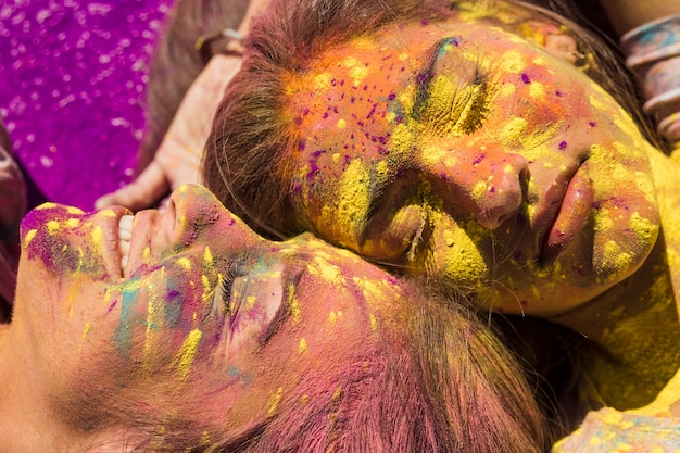 Nahaufnahme des gesichtes der jungen frauen bedeckt mit holi farbe