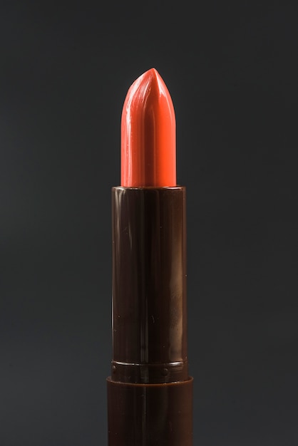 Kostenloses Foto nahaufnahme des glänzenden roten lippenstifts gegen schwarzen hintergrund
