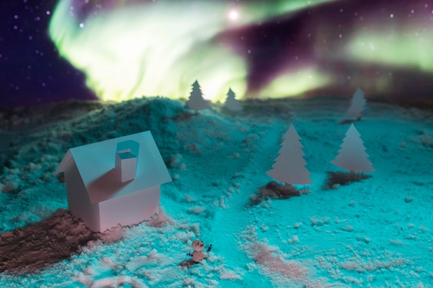 Nahaufnahme des Hauses auf Schnee mit Aurora Borealis