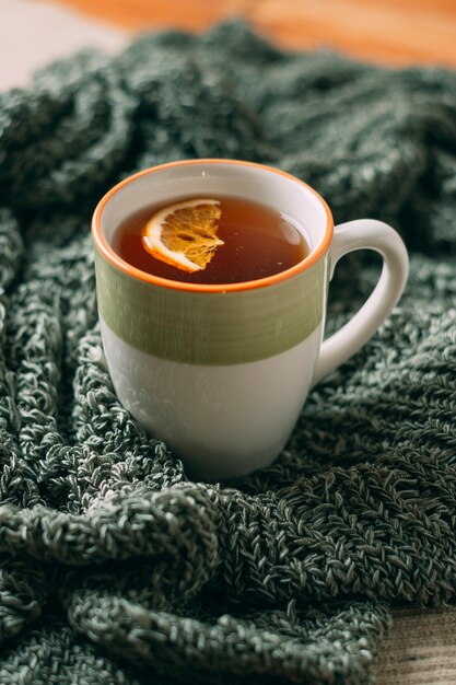 Nahaufnahme des heißen Tees mit Orange auf Schal