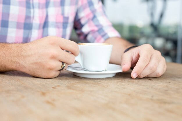 Nahaufnahme des jungen Mannes Kaffee draußen trinkend