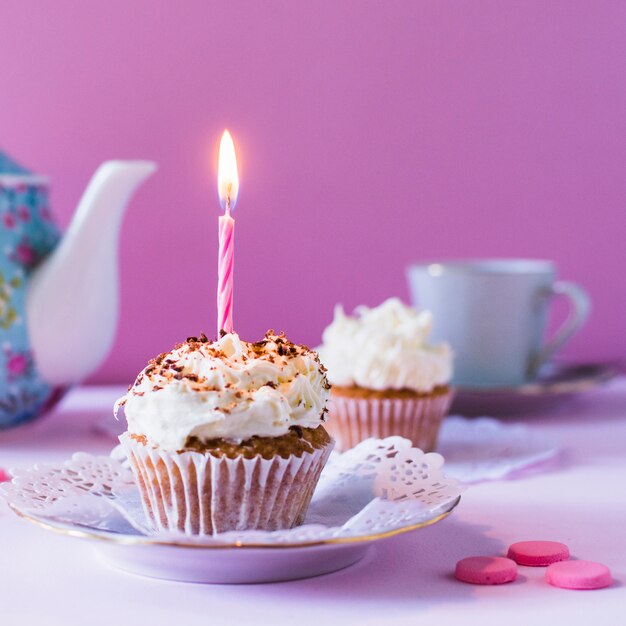 Nahaufnahme des kleinen Kuchens mit brennender Kerze am Geburtstag