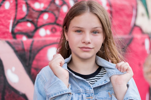 Kostenloses Foto nahaufnahme des lächelnden schönen mädchens, das ihren hemdkragen hält