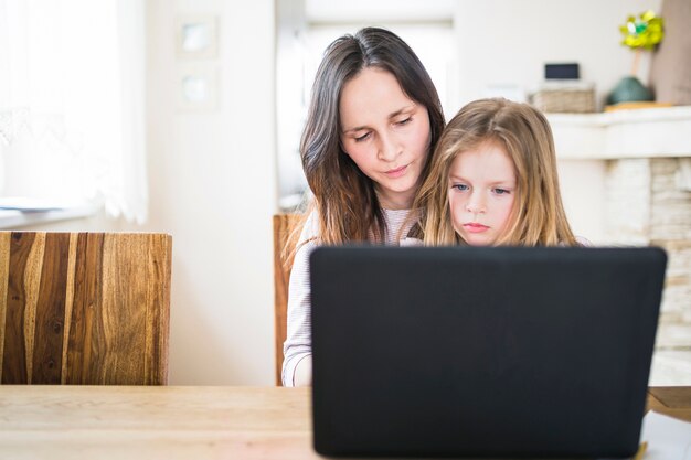 Nahaufnahme des Laptops vor Mutter mit ihrer Tochter