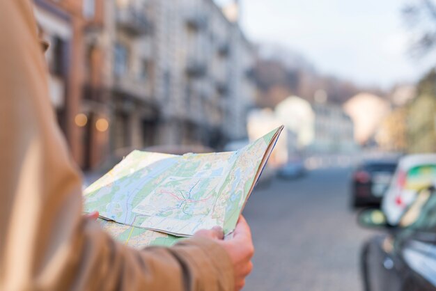 Nahaufnahme des männlichen Reisenden die Karte in der Hand halten, die auf Stadtstraße steht