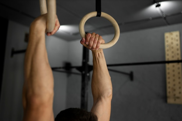 Kostenloses Foto nahaufnahme des mannes, der arme im fitnessstudio trainiert