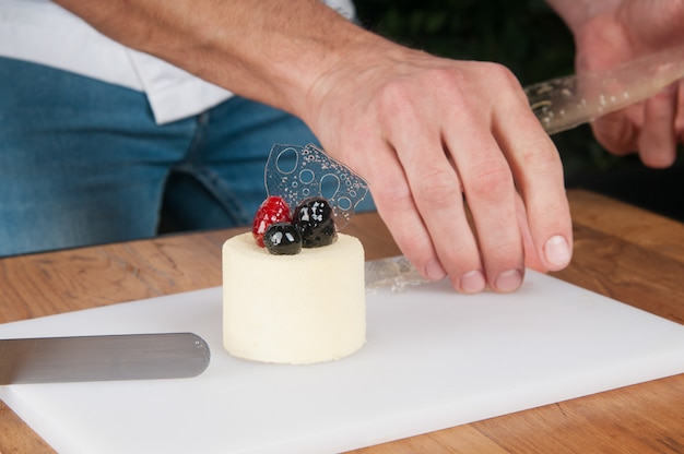 Nahaufnahme des Mannes Eiscreme mit Eis bei Tisch verzierend