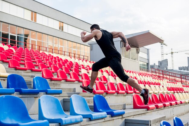 Nahaufnahme des Mannes Treppe auf den Stadionstühlen oben laufen lassend