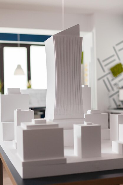 Nahaufnahme des maßstabsgetreuen 3D-Architekturmodells aus weißem Schaum des Wolkenkratzer-Gebäudekomplexes im modernen Architektenbüro. Detail des Stadtentwicklungsprojekts auf dem Designtisch.