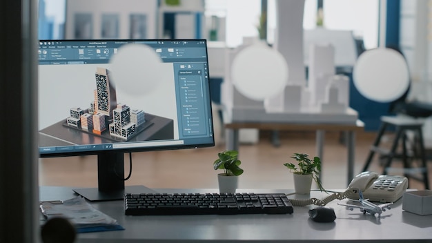 Nahaufnahme des Monitors mit 3D-Gebäude und Konstruktionsplan auf dem Tisch im Büro. Städtische Immobilienstruktur am Computer zur Planung des architektonischen Entwicklungsprojekts. Grafikdesign