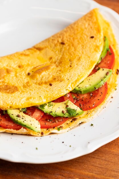 Nahaufnahme des Omeletts mit Tomaten und Avocado auf Teller