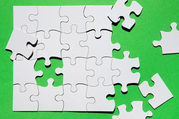 Nahaufnahme des Puzzlespielstückes auf grünem Hintergrund