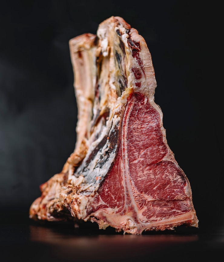 Kostenlose Foto nahaufnahme des rohen t-bone-rindfleischsteaks, das auf marineblau gelegt wird