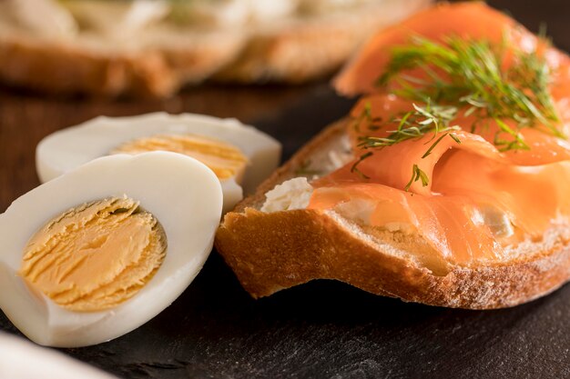 Nahaufnahme des Sandwichs auf Schiefer mit Lachs und hart gekochtem Ei