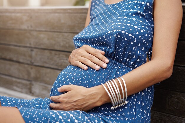 Nahaufnahme des schwangeren Bauches der Frau, die Baby erwartet.