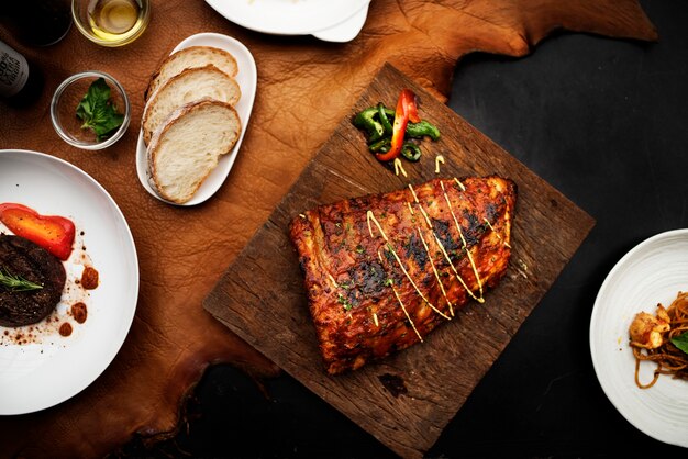 Nahaufnahme des Schweinefleischrippensteaks auf Lebensmittelanreden des hölzernen Brettes