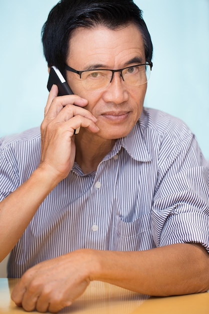 Nahaufnahme des Senior Asian Man Telefon ersucht