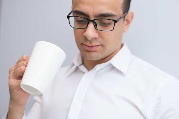 Nahaufnahme des starken Geschäftsmannes in den Gläsern Kaffee trinkend