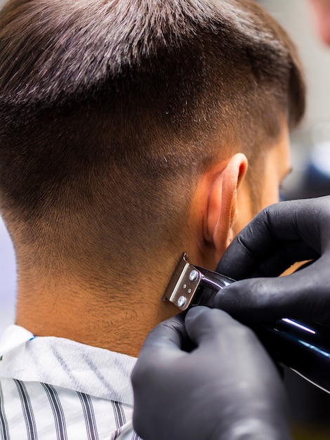 Nahaufnahme des Trimmers und der schwarzen Handschuhe