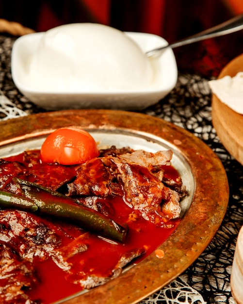 Nahaufnahme des türkischen Ikender-Kebabs, garniert mit Tomatensauce und gegrilltem Pfeffer
