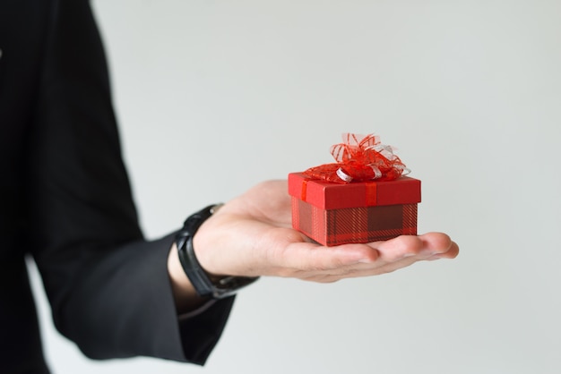 Nahaufnahme des unerkennbaren Mannes, der kleines Geschenk auf Palme hält