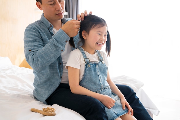 Nahaufnahme des Vaters, der die Haare des Mädchens bindet