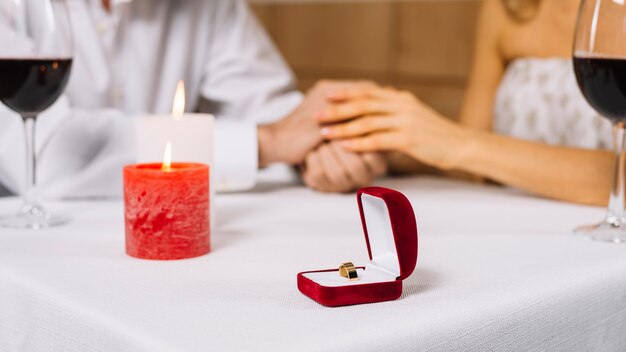 Nahaufnahme des Verlobungsrings und der Kerzen